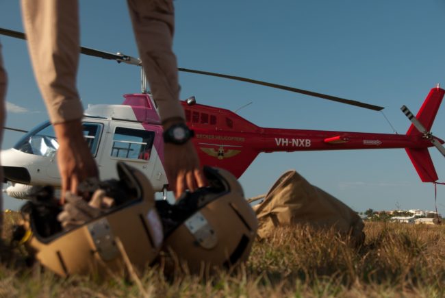 Trainee pilots picking up helmets in preparation for a training flight